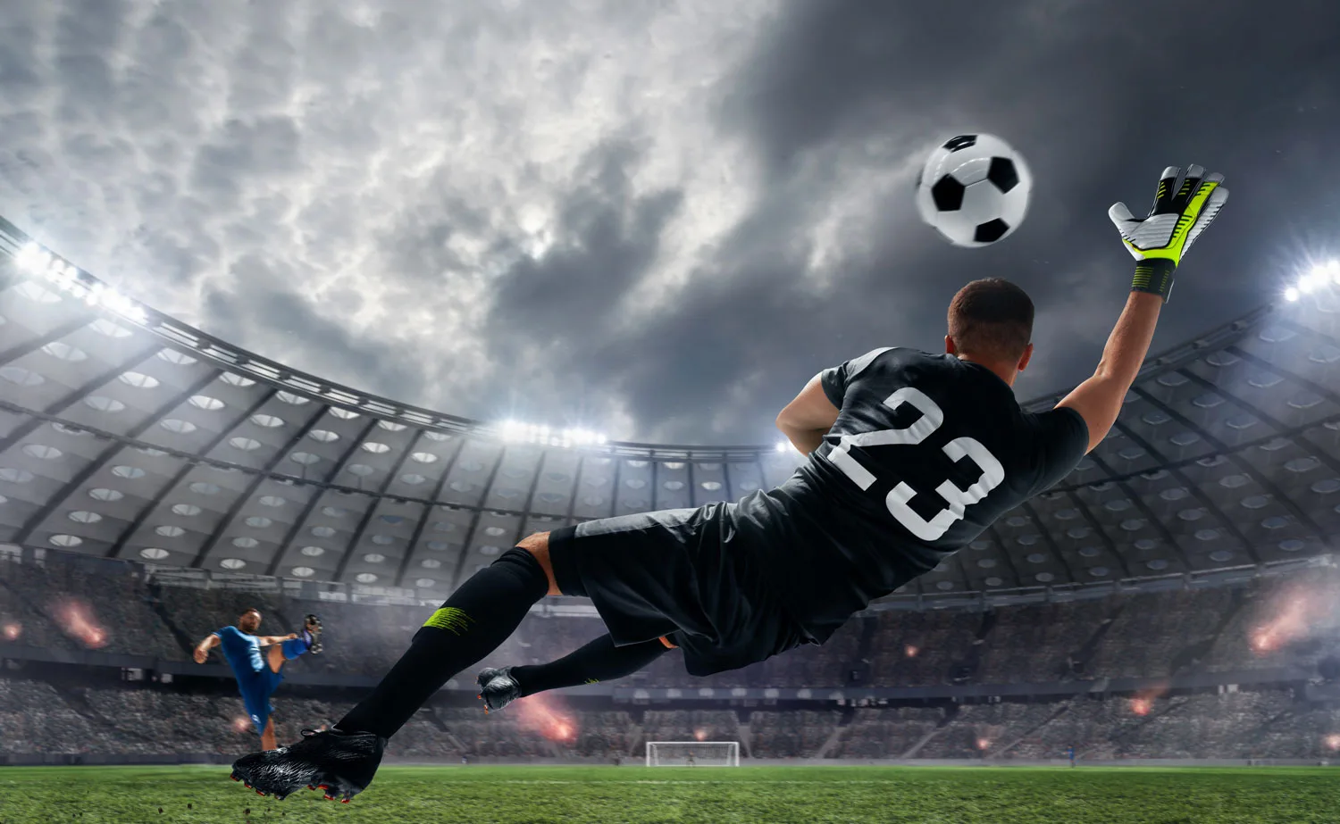 Footballer in a number 23 kit making a bicycle kick in a floodlit stadium