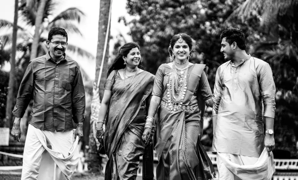 Family walking together in black and white, candid wedding photography Bangalore