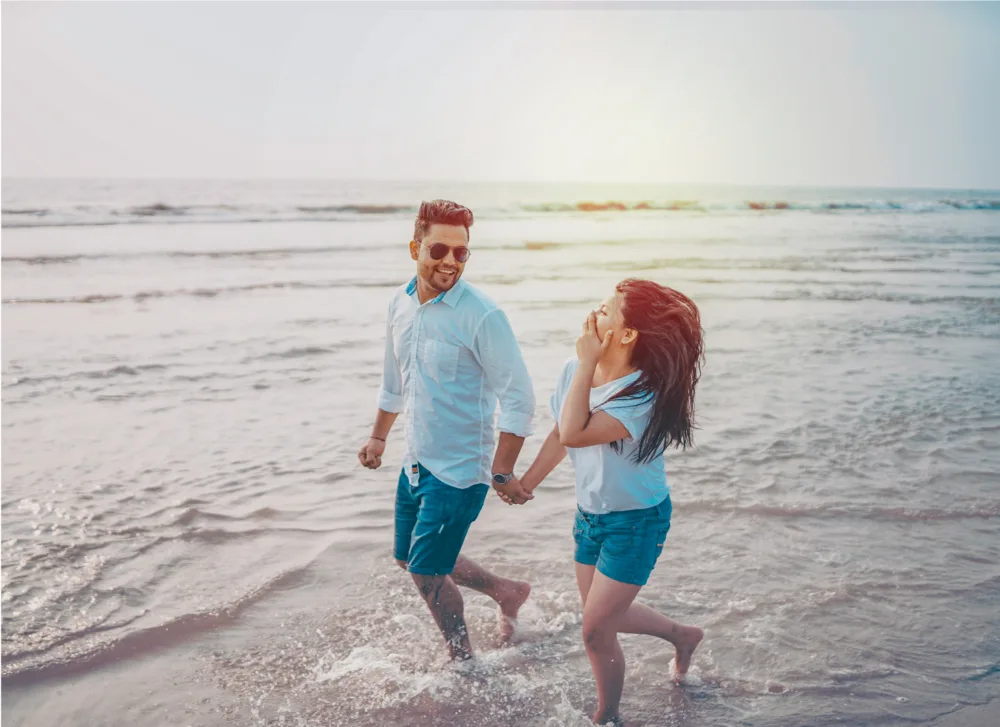 Couple walking hand in hand at the water's edge, pre-wedding photography Bangalore