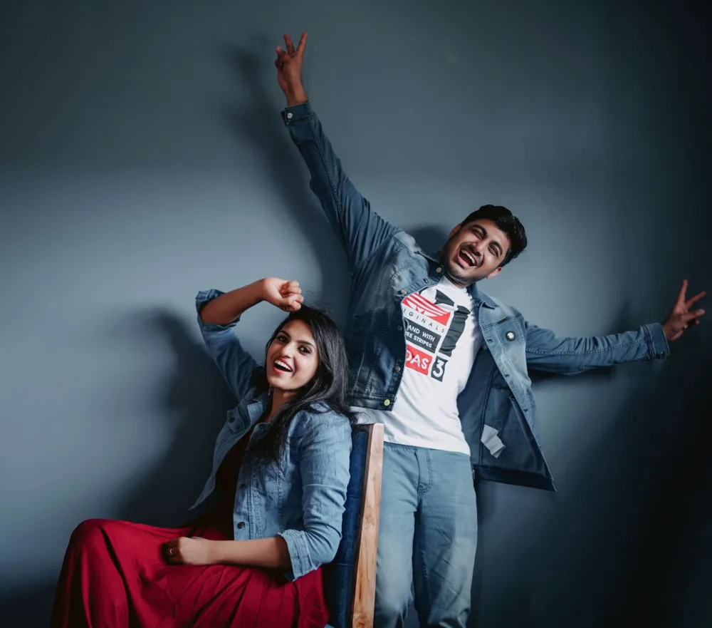 Couple posing playfully against a studio backdrop, pre-wedding photography Bangalore
